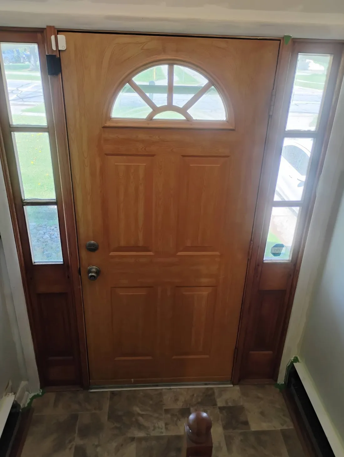 Front entry before, with a dated stained wood door and trim