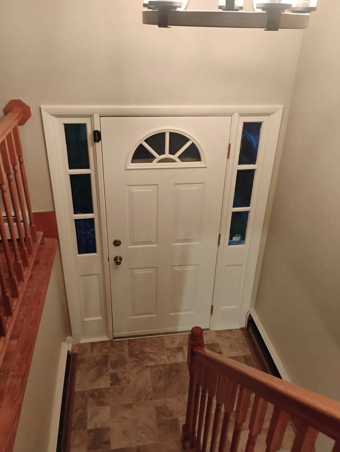 Bright finished entryway with a freshly painted white front door