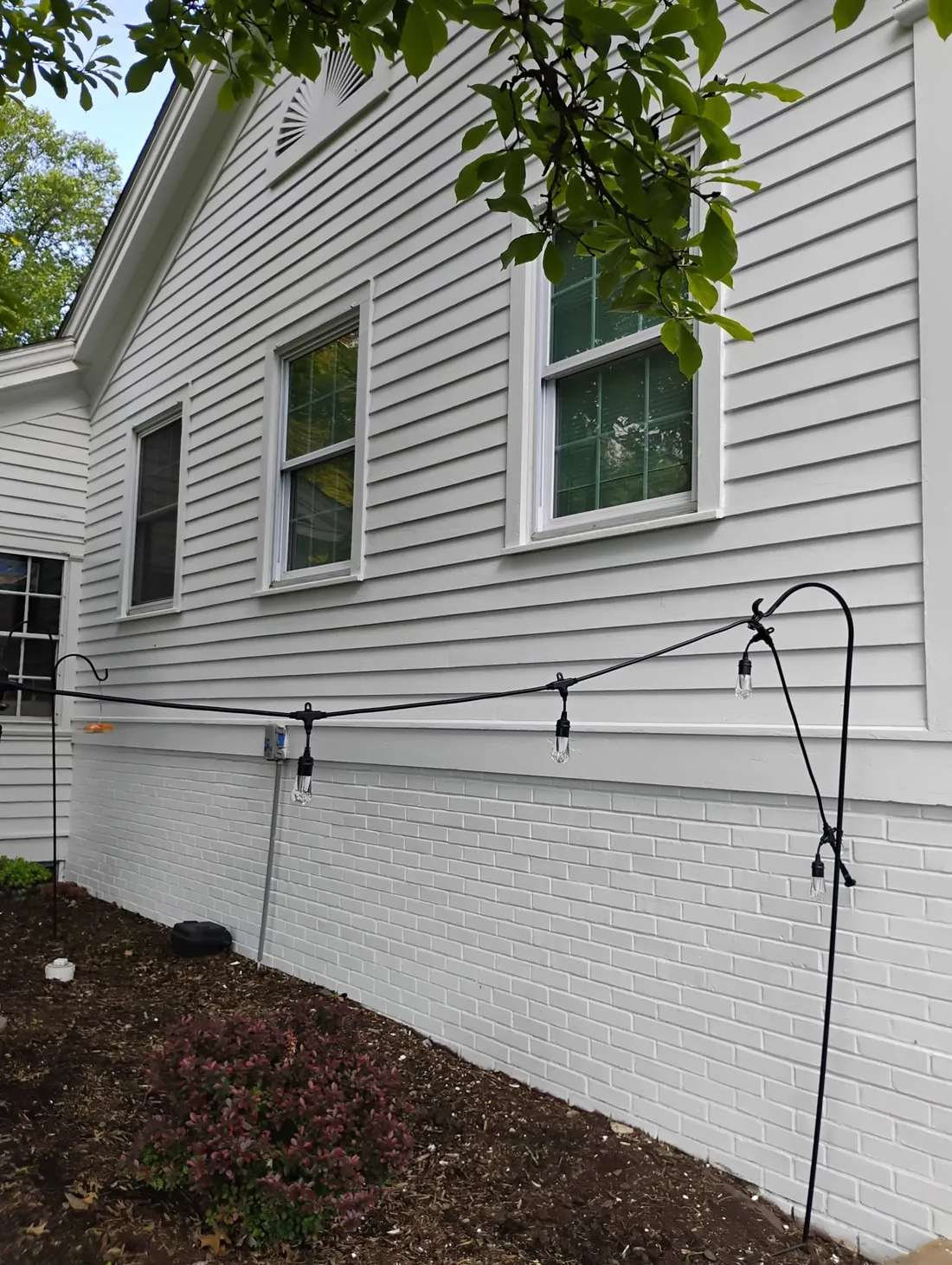 Freshly painted home exterior with light gray siding and white trim