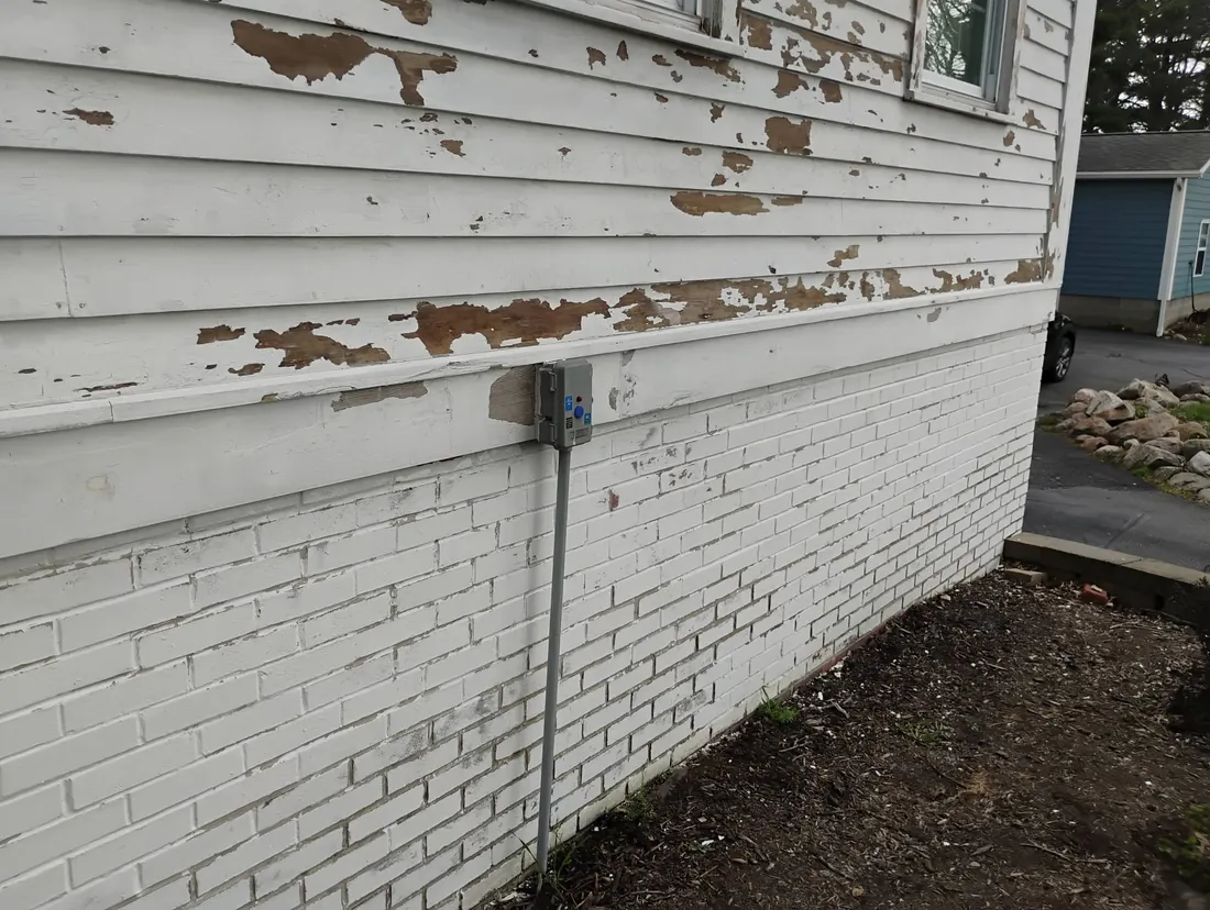 Building exterior before, with heavily failing and peeling paint