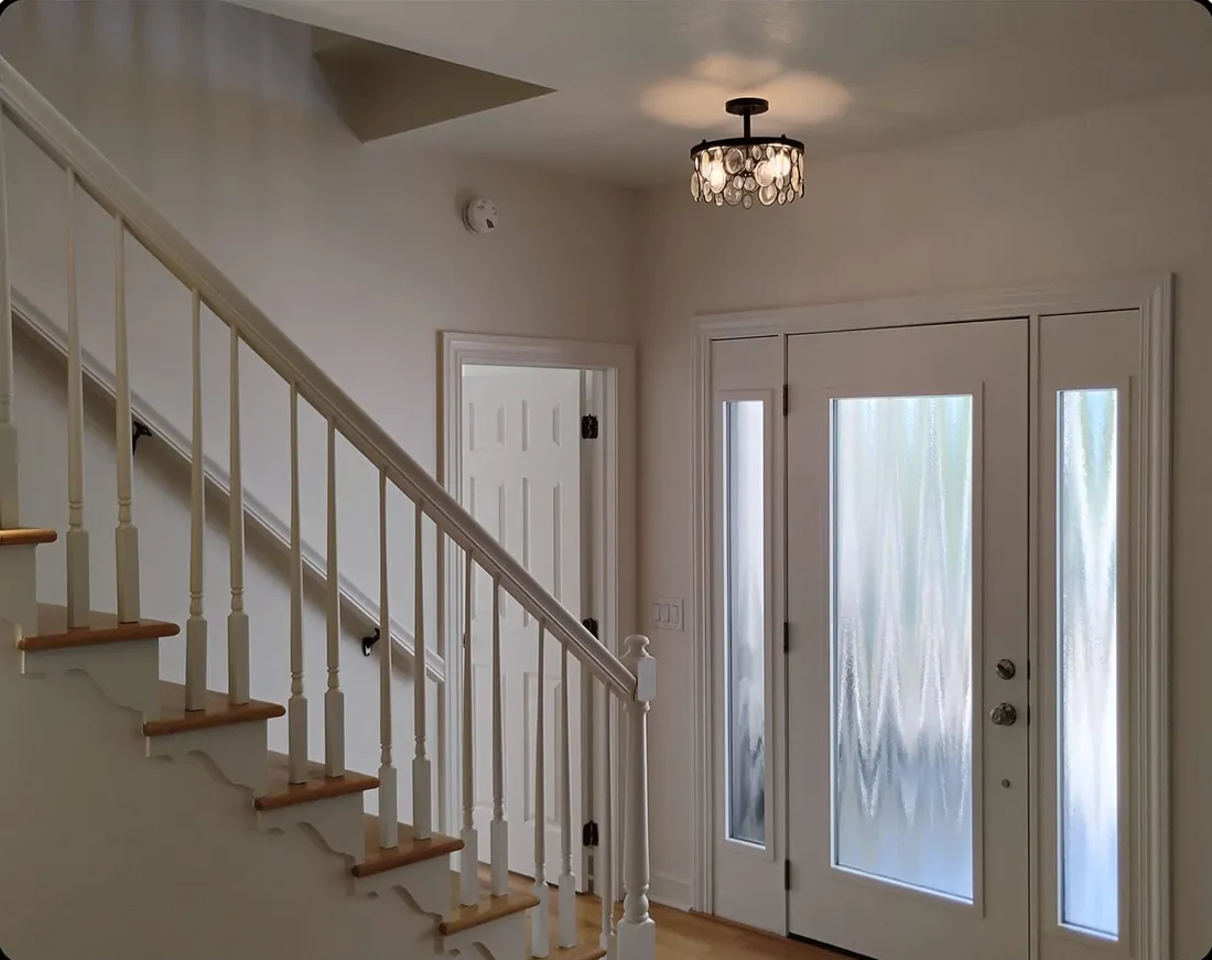 Same entry and staircase after, painted bright and current